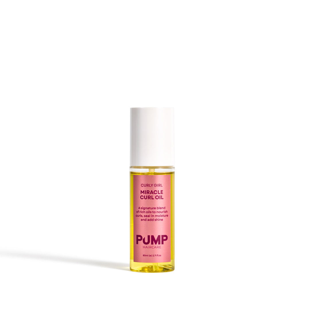 Pump Miracle Curl Oil in a clear cylindrical bottle showing golden-yellow oil inside, with a pink label and a white cap, set against a plain white background.